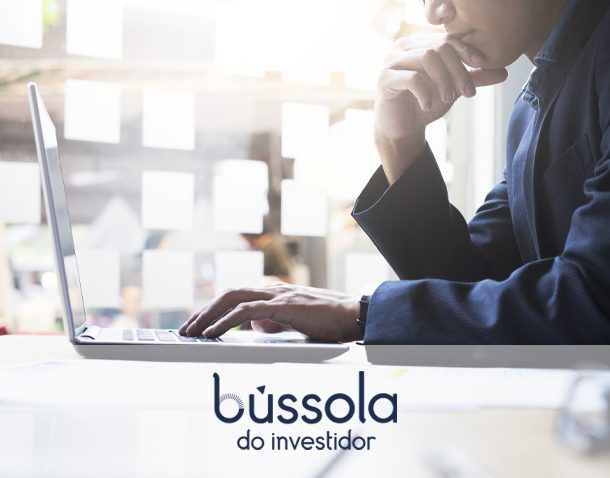 Homem na frente do computador aprendendo a investir em mini dólar com a Bússola do Investidor