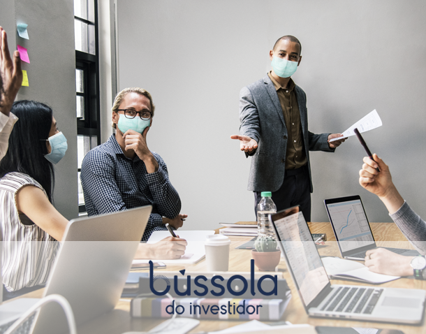 Pessoas em uma mesa discutindo se vale a pena investir durante a pandemia