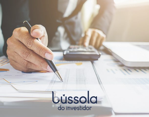 Mão no papel analisando investimentos em alta